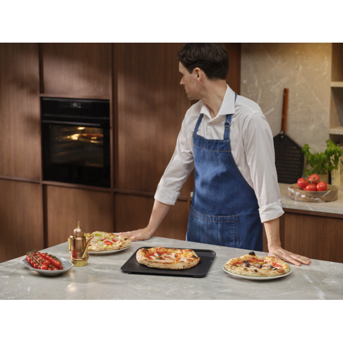 Person with the pizza expert oven and cast iron tray with Neapolitan pizzas 