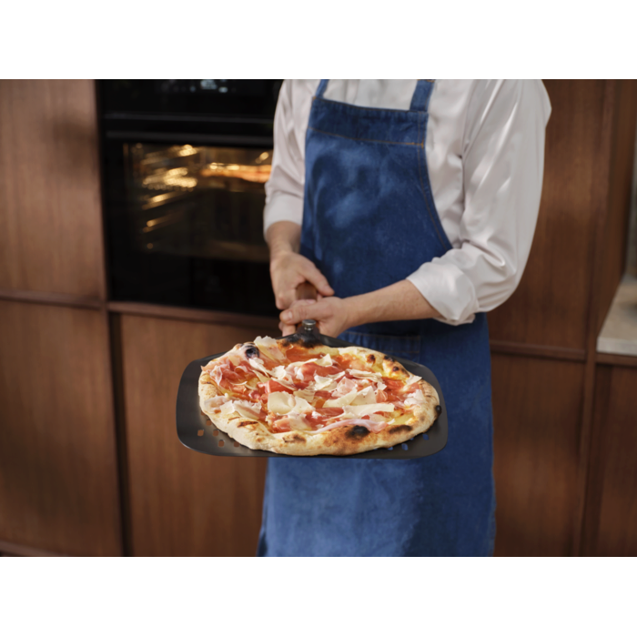 Person holding the pizza expert pizza peel with a Neapolitan pizza