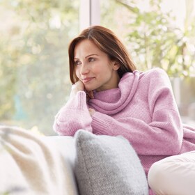 O doamnă care se bucură de puloverul ei din lână